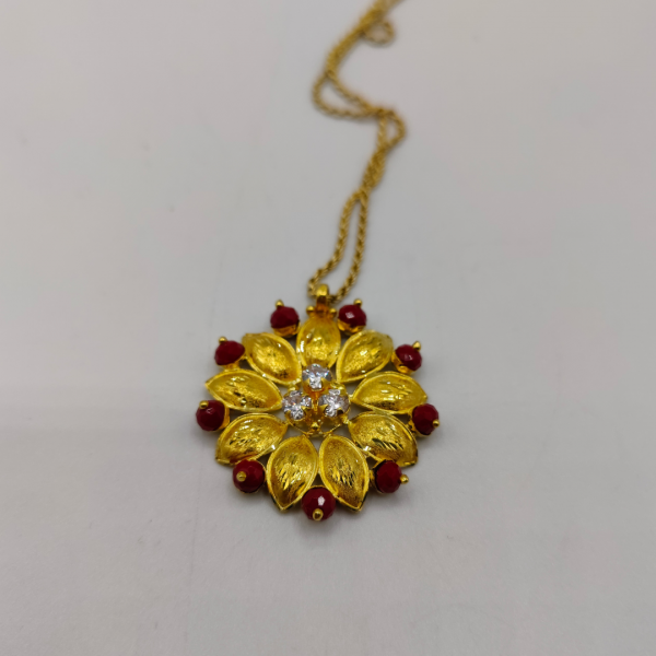 Colgante flor con 3 circonitas en el centro y circonitas intercaladas en los petalos de color granate oro de 22 k REF: CG218 Nueva