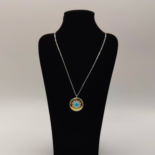 Collar de plata con colgante tipo medalla en color dorado con flor de circonitas y en el centro una piedra azul