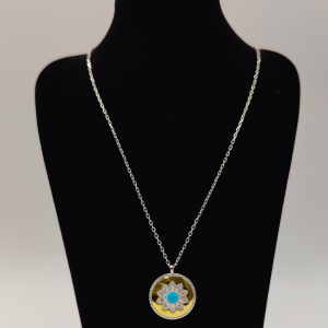 Collar de plata con colgante tipo medalla en color dorado con flor de circonitas y en el centro una piedra azul