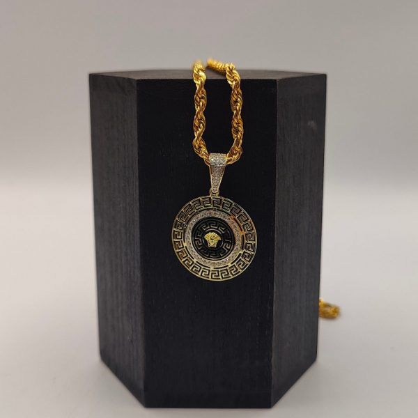 Colgante Versace con circonitas, diseño trocado y esmaltado negro con la cara de Medusa en el centro, en oro de 18k
