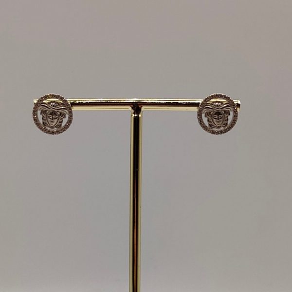 Pendiente cara estilo Versace con circonitas enmarcando la figura y plata