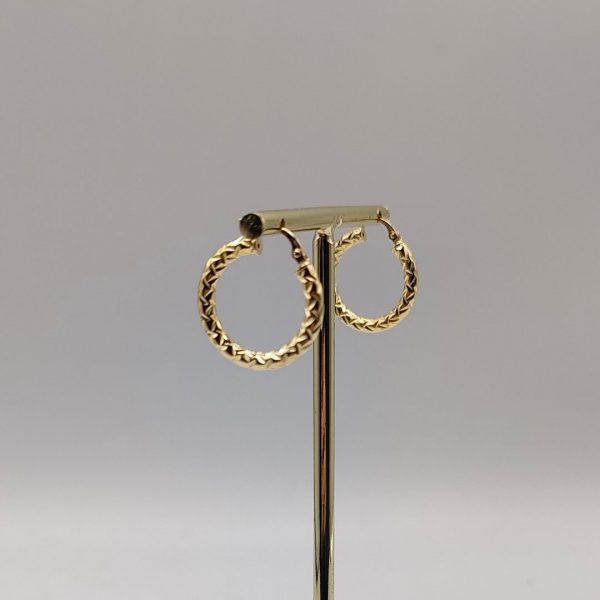 Este pendiente de aro de 2 cm de diámetro y 3 mm de ancho presenta una textura elegante que le da un toque sofisticado y moderno. Fabricado en oro de 18K