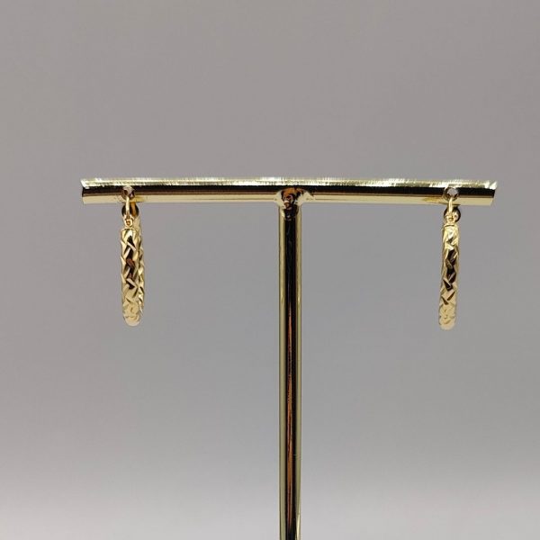 Este pendiente de aro de 2 cm de diámetro y 3 mm de ancho presenta una textura elegante que le da un toque sofisticado y moderno. Fabricado en oro de 18K